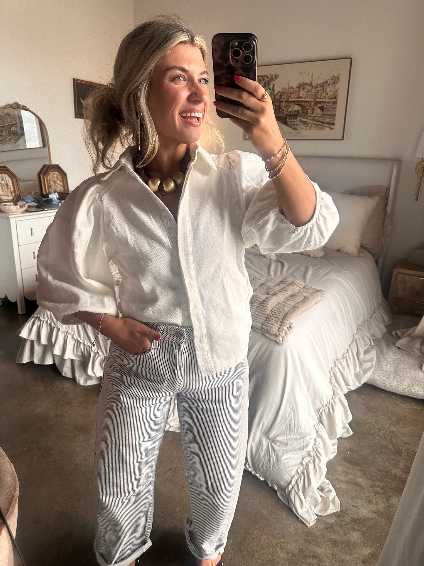 White puff sleeve button-up blouse with textured cotton fabric styled with striped pants and braided sandals for a coastal chic summer outfit.