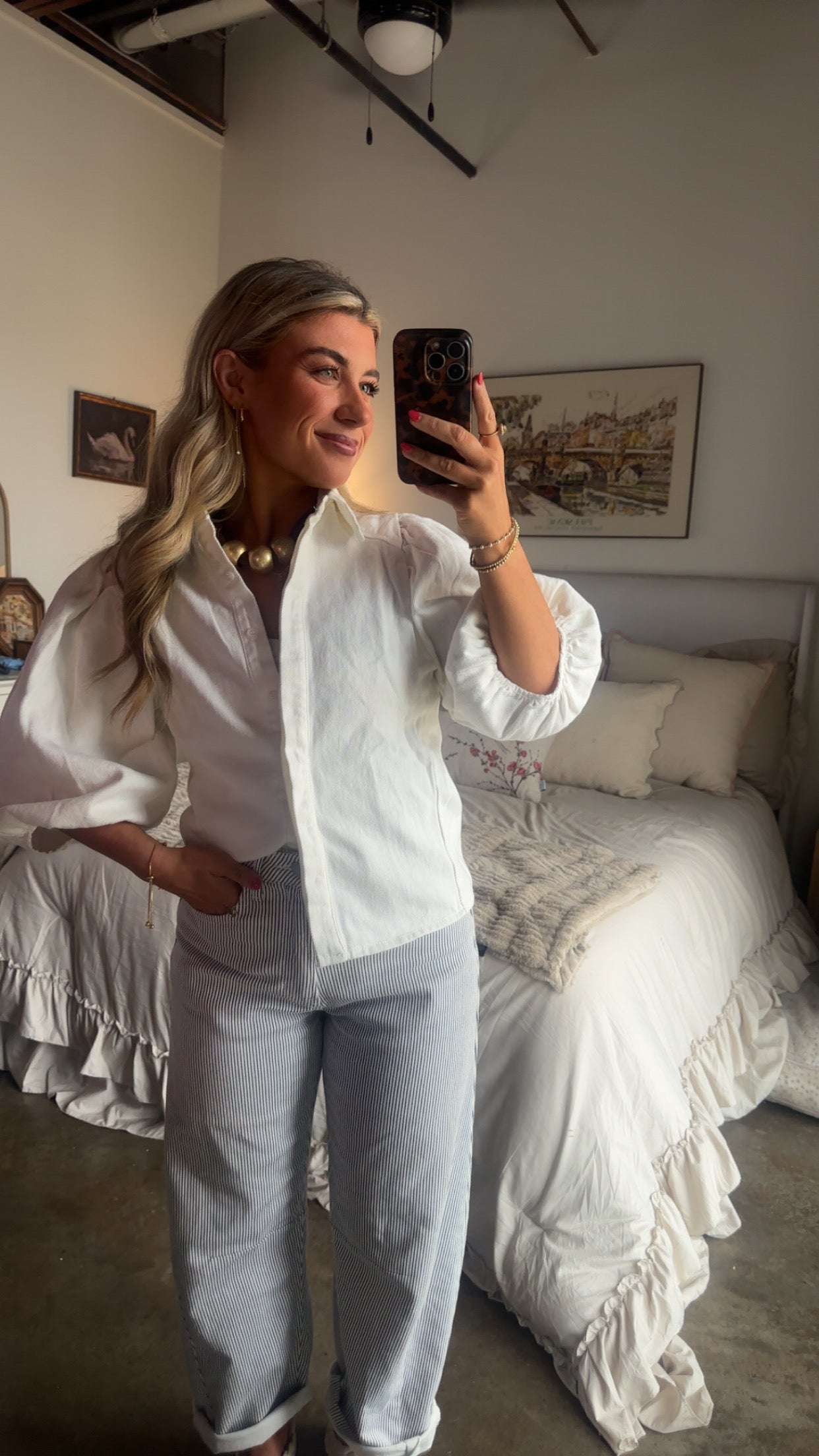 White puff sleeve button-up blouse with textured cotton fabric styled with striped pants and braided sandals for a coastal chic summer outfit.