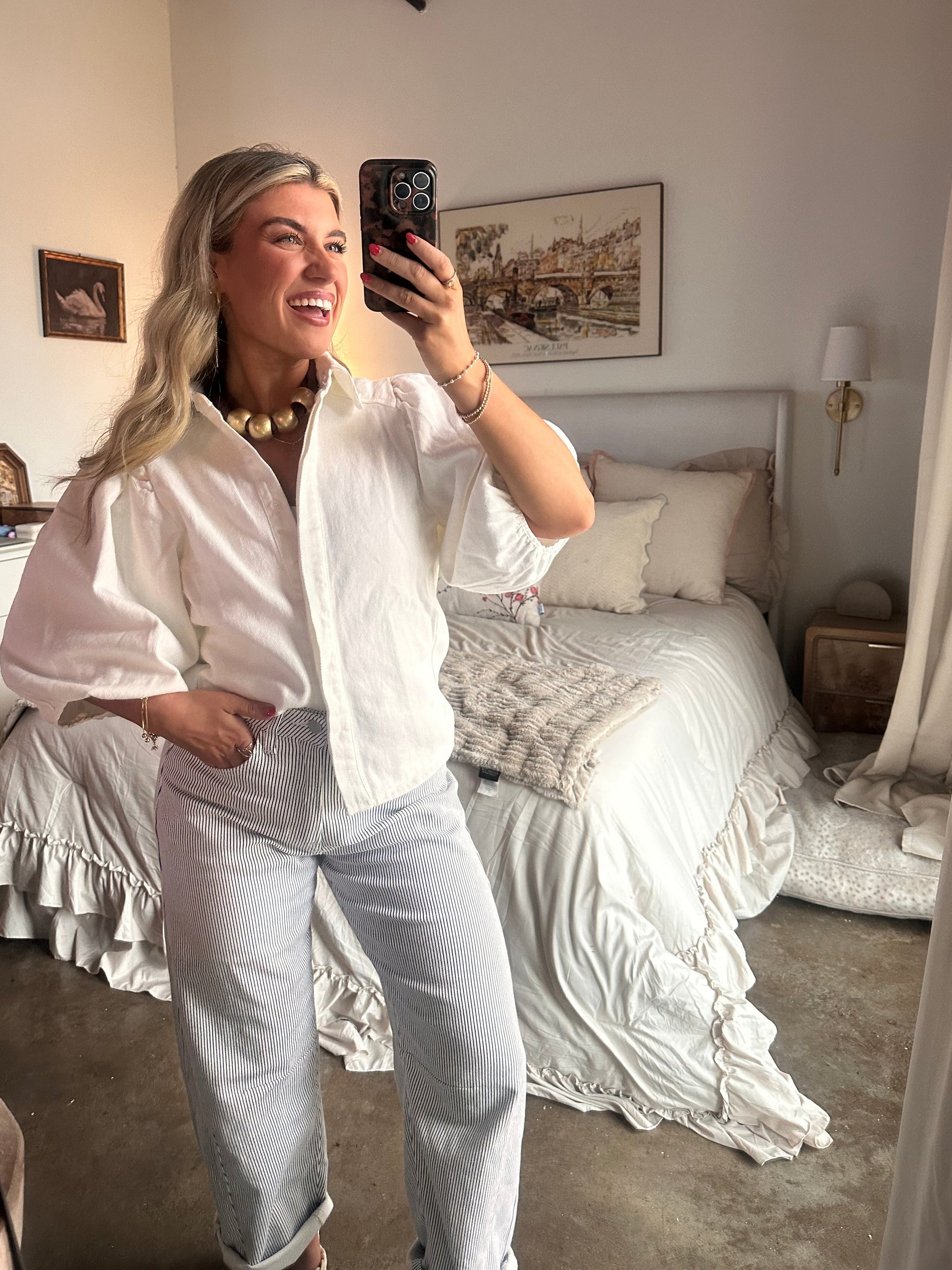 White puff sleeve button-up blouse with textured cotton fabric styled with striped pants and braided sandals for a coastal chic summer outfit.
